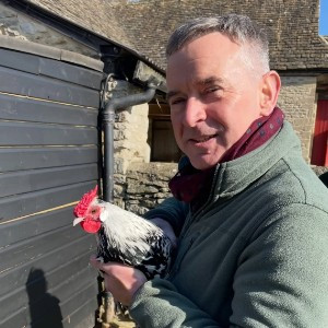 Guy Reed, General Manager of Cogges Manor Farm, holding a chicken