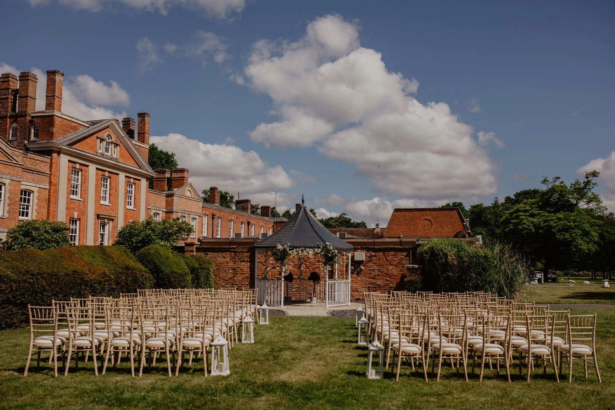 Outdoor wedding ceremony at Warbrook House, the country house venue is the backdrop