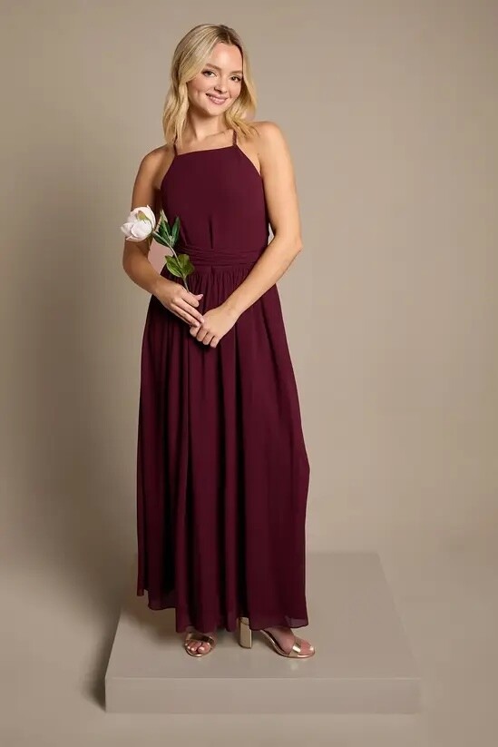 Teen bridesmaid wearing a floor-length fig chiffon bridesmaid dress with a cami neckline and flowing skirt.
