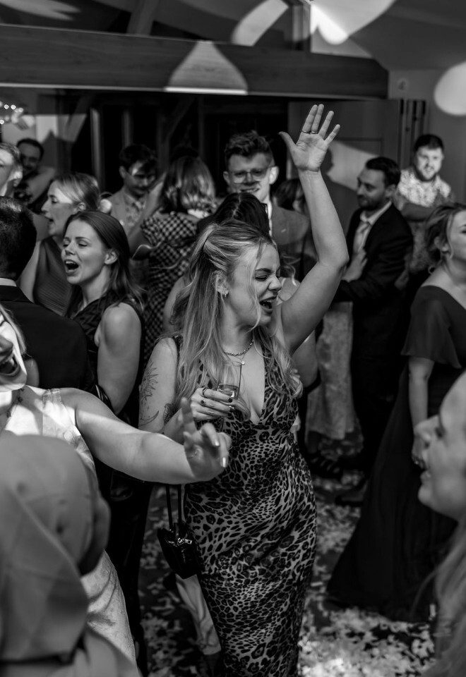 Guests dancing on a packed dance floor during wedding evening reception.