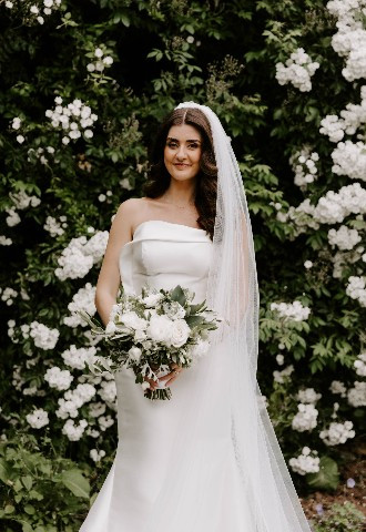 Bride outside showcasing wedding dress at Glewstone Court