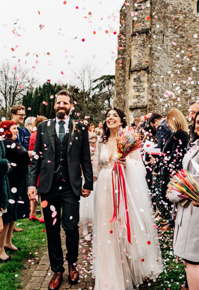 Rebecca and Toby leaving the church as husband and wife through biodegradable paper confetti