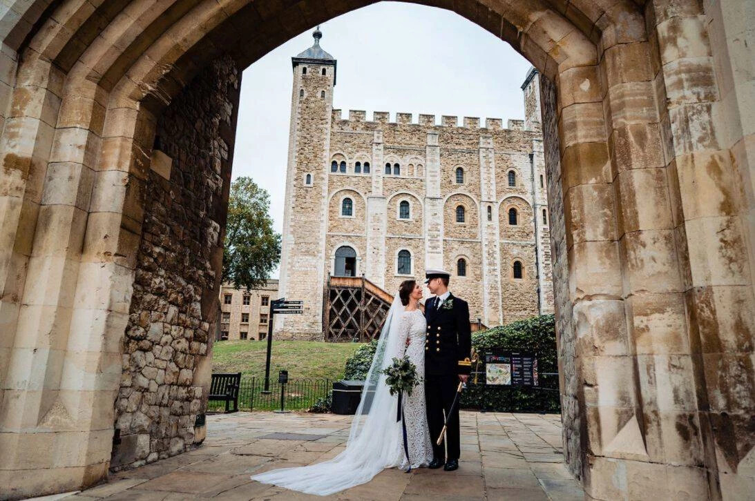 Bride and groom standing beneath the archways of The Tower of London