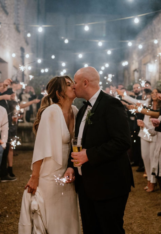 Bride and groom kissing at sparkler exit 