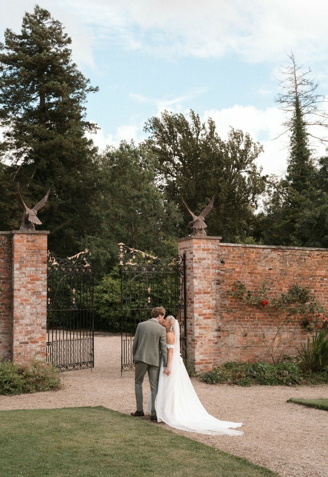 Bride and groom kiss in walled garden of wedding venue, Elmhay Park