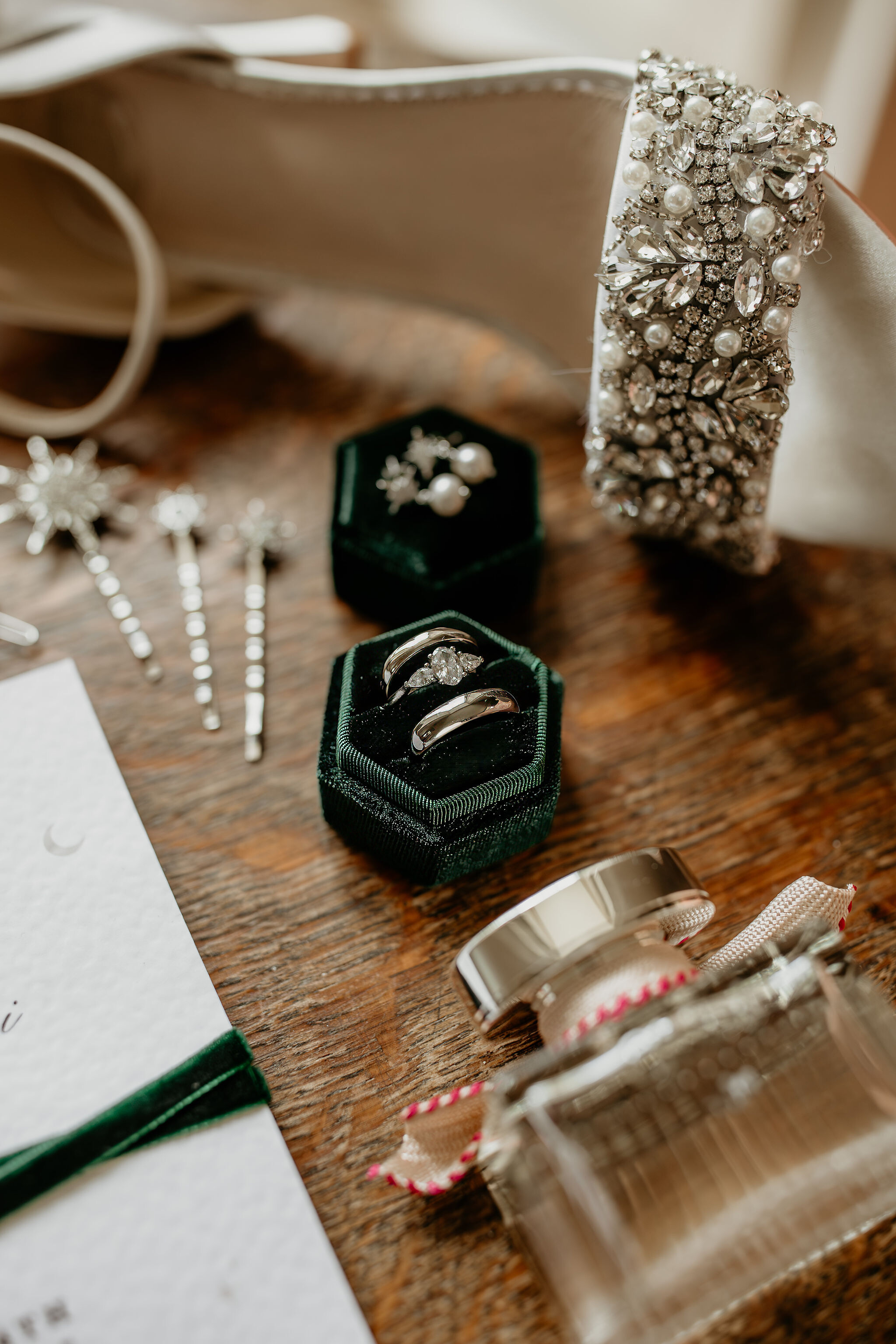 His and hers wedding rings with an oval cut diamond ring with with pear cut diamonds in a velvet green box as a flat lay detail shot at Tredudwell Manor Wedding Venue in Cornwall