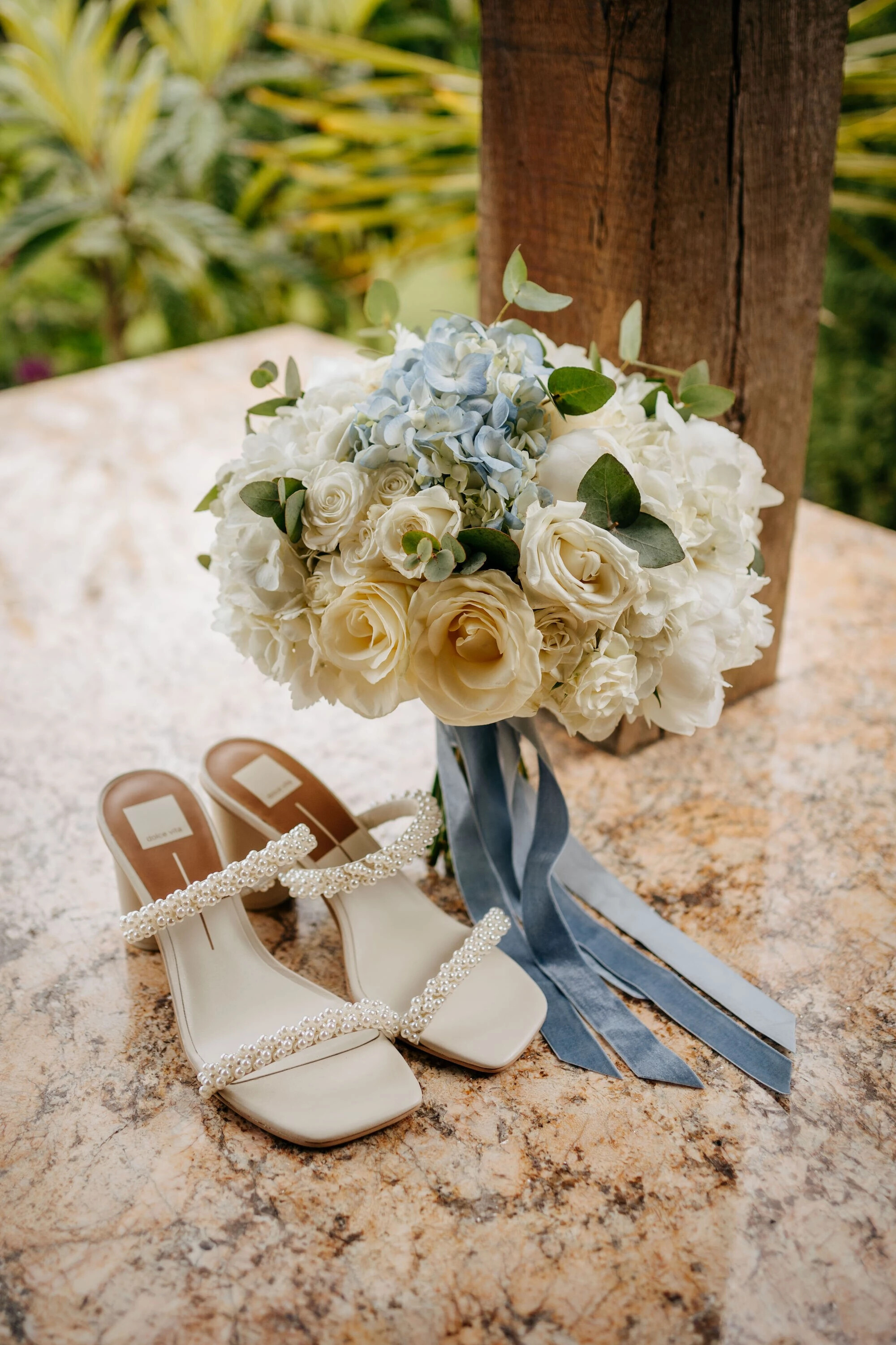 Brides bouquet with white and blue flowers available in the late spring and her wedding shoes
