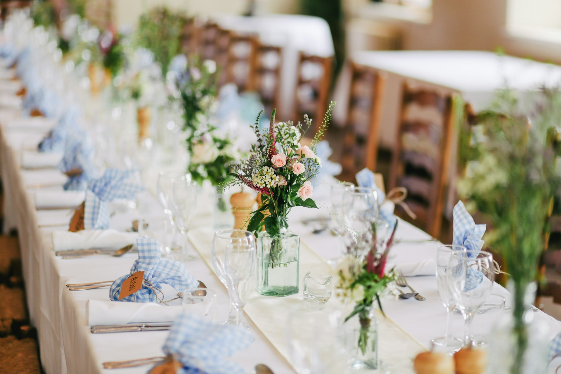 Wedding reception table set with floral centrepieces and place settings