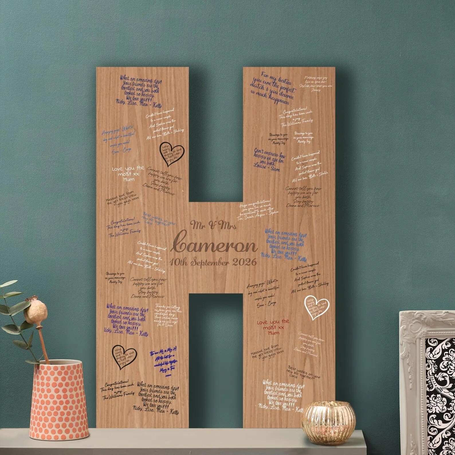 Wooden cross-shaped guest book alternative with engraved names and wedding date, covered in handwritten messages from guests and displayed as a keepsake piece.