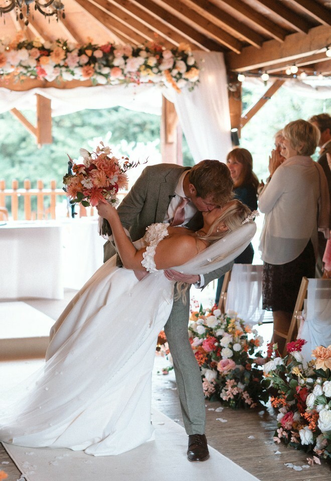Bride and groom kiss in the centre of the aisle