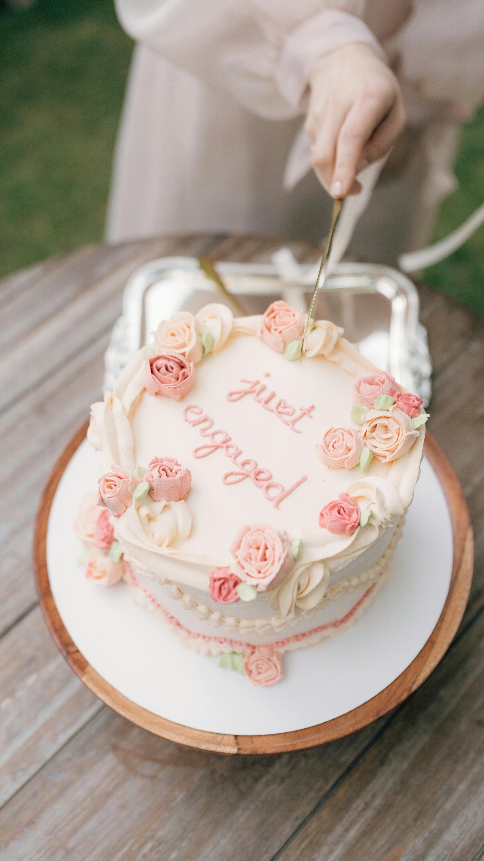 Engagement party, cake is being cut which reads "just engaged"