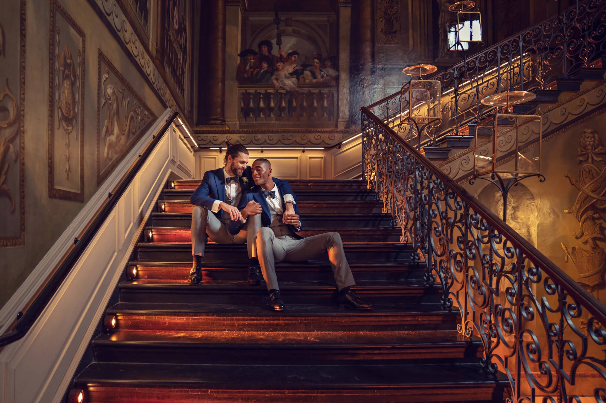 Groom and groom sit on the Kings Staircase inside Kensington Palace