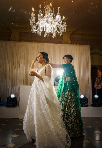 Ana and Satveer walking onto the dancefloor holding hands