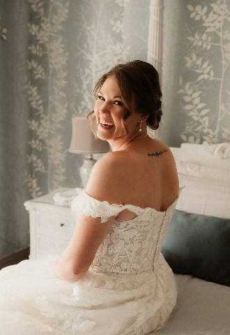 Bride sat on bed ready for wedding day at Southdowns Manor West Sussex