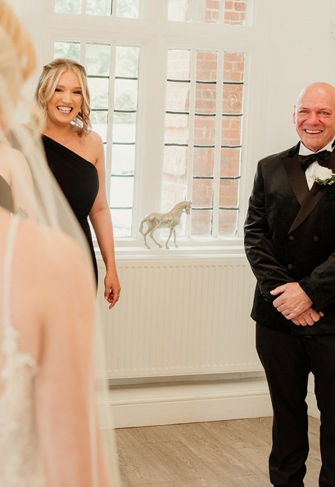 Chloes father smiling and looking at her in the wedding dress