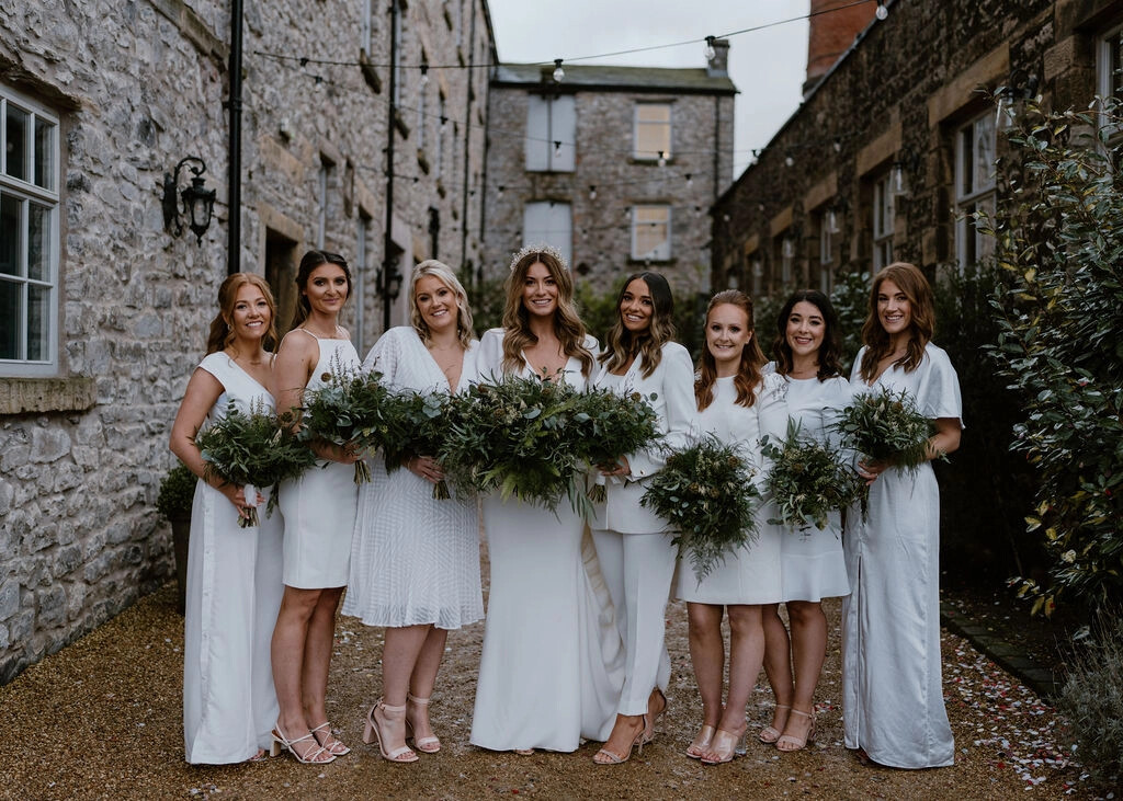 Bride and bridesmaids holding foliage heavy bouquets for a winter wedding