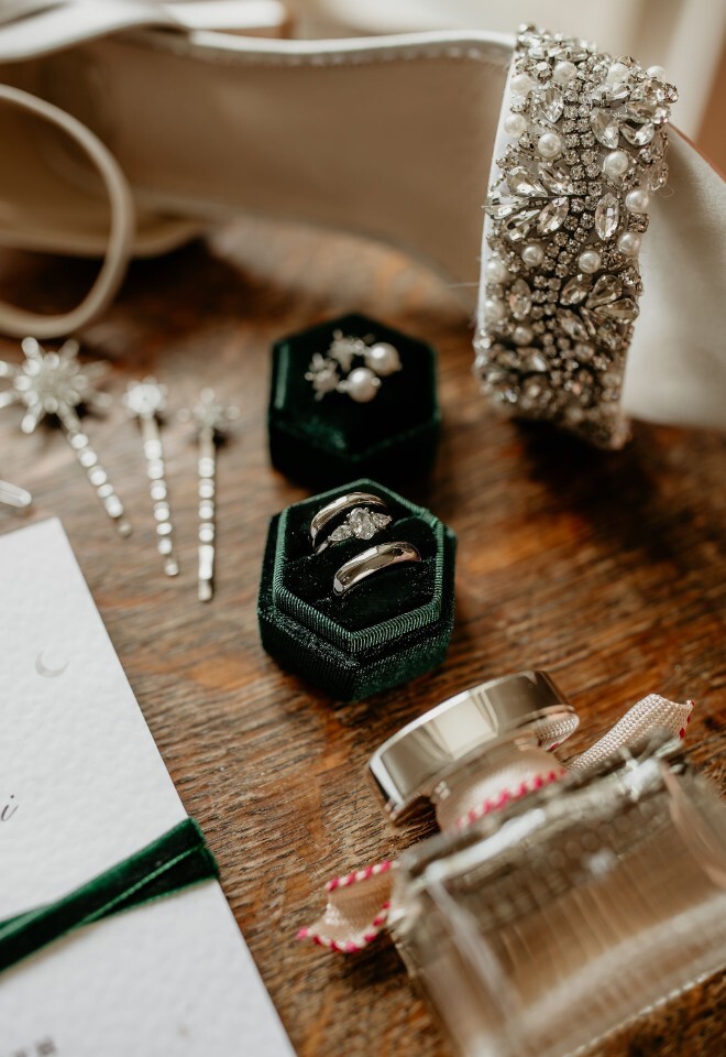 Wedding accessories and rings in a green velvet box with embellished heels and jewellery.