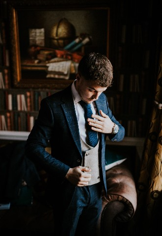 Groom getting ready in library at Hedsor House wedding venue Buckinghamshire