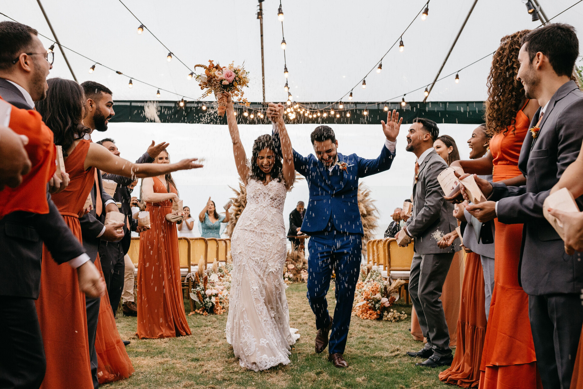 Newly married couple celebrating with guests during an outdoor wedding reception