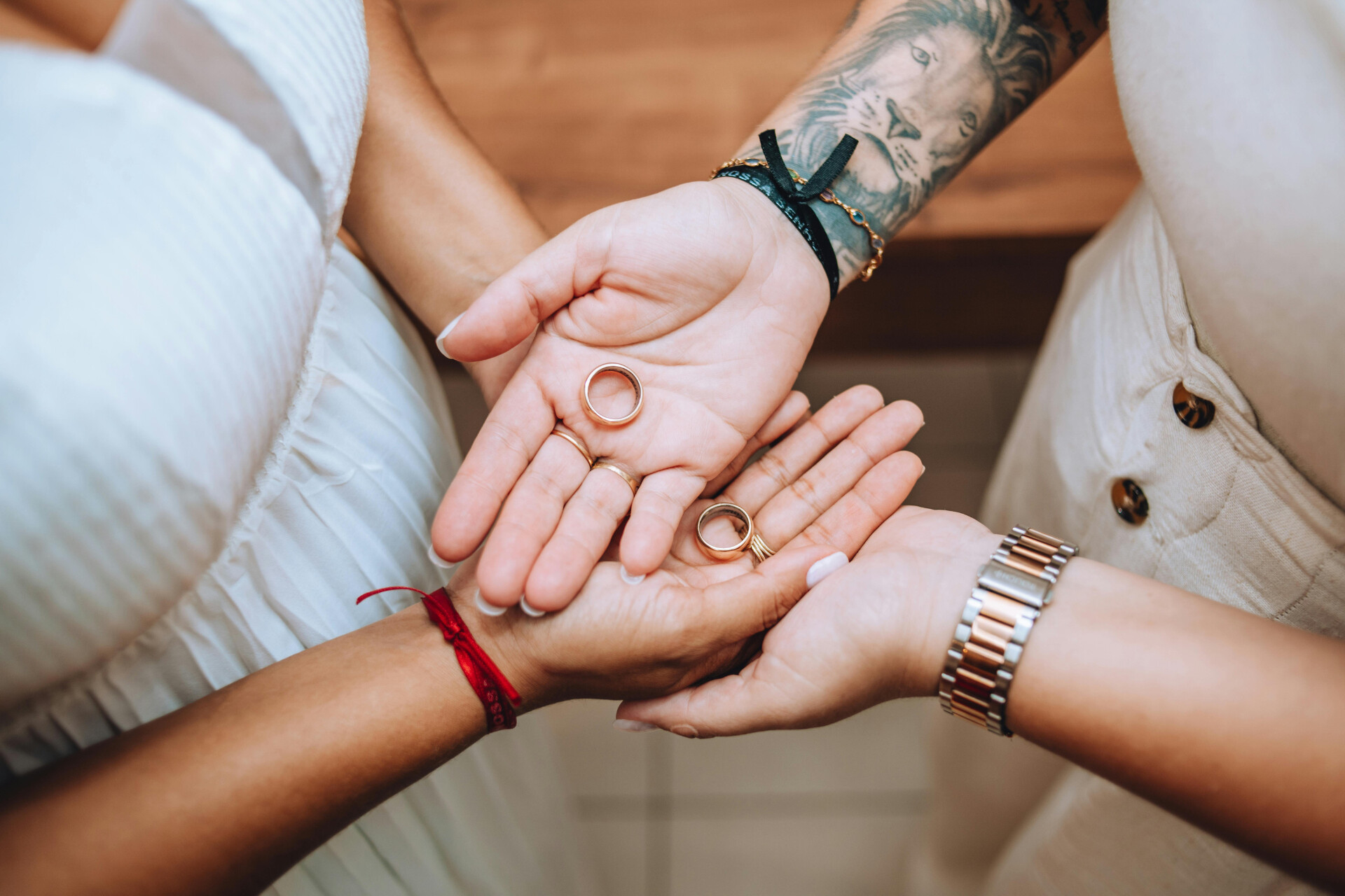 Wedding rings held in the hands of a same-sex couple before their wedding ceremony