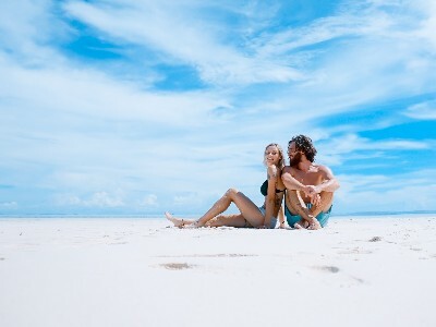 Couple relaxing on beach during honeymoon