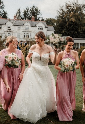 Bride and bridesmaid photos dancing outside Southdowns Manor West Sussex