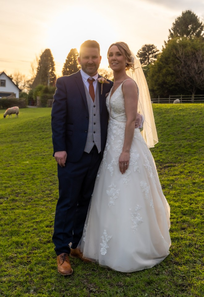 bride and groom stood in front of the sunset