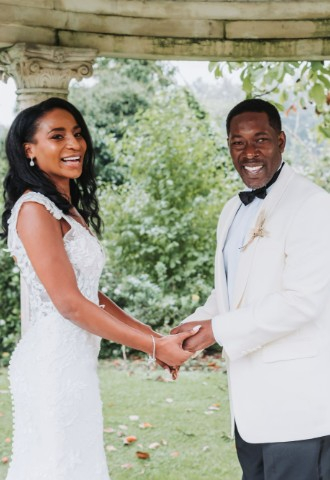 Bride and Groom stood with celebrant Beth Whaley all looking off to the right and laughing