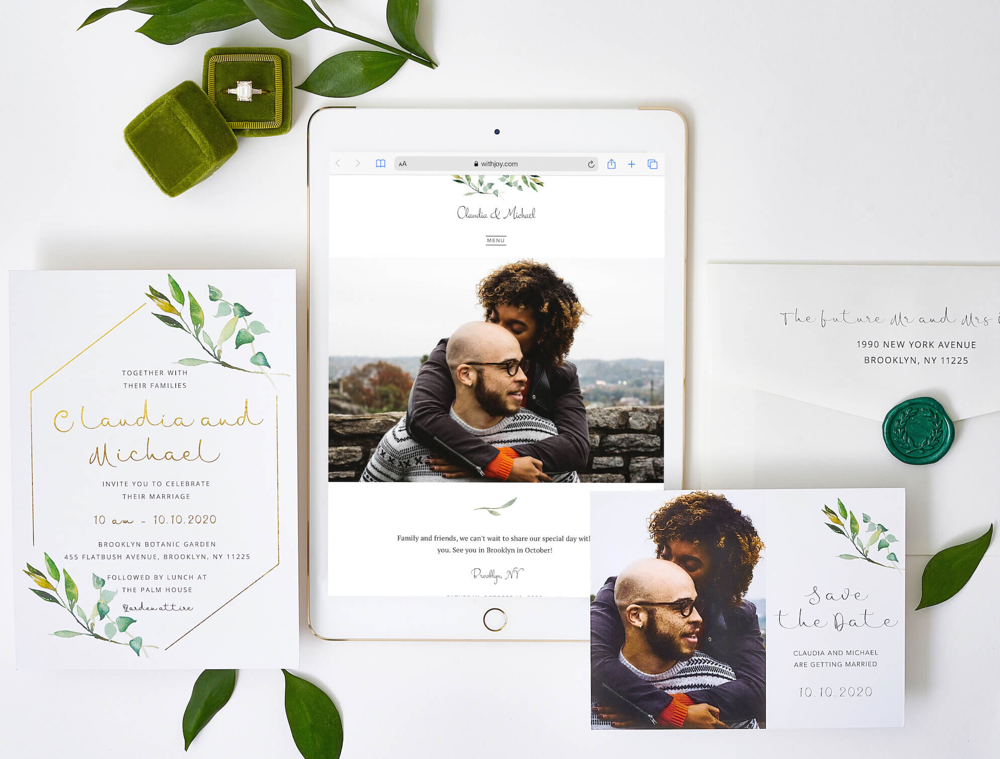 WithJoy wedding website displayed on tablet with matching botanical wedding stationery, save the date cards and engagement ring.