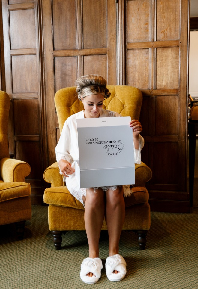 Bride opens present from groom on wedding morning