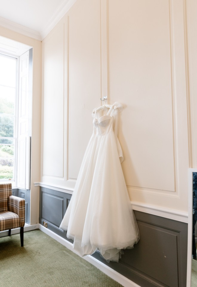 Wedding dress hangs up in the dressing room at Wotton House