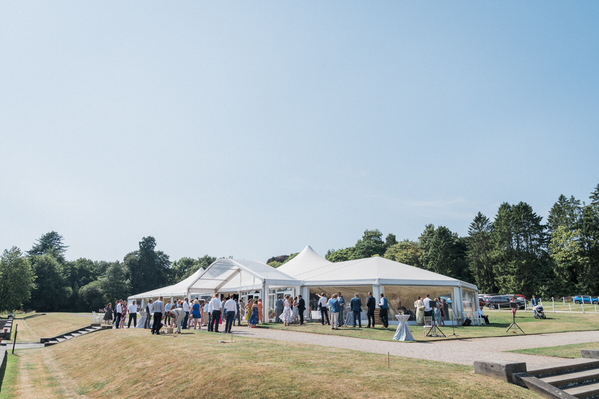 Large wedding marquee reception with panoramic sides and outdoor drinks area at Osmaston Park.