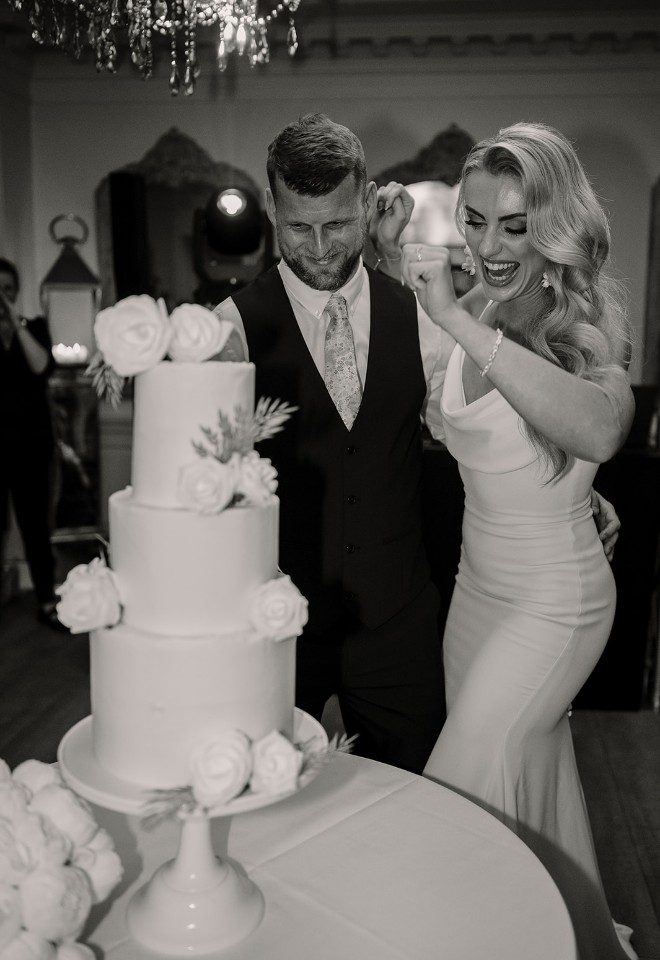 Bride and groom cutting wedding cake