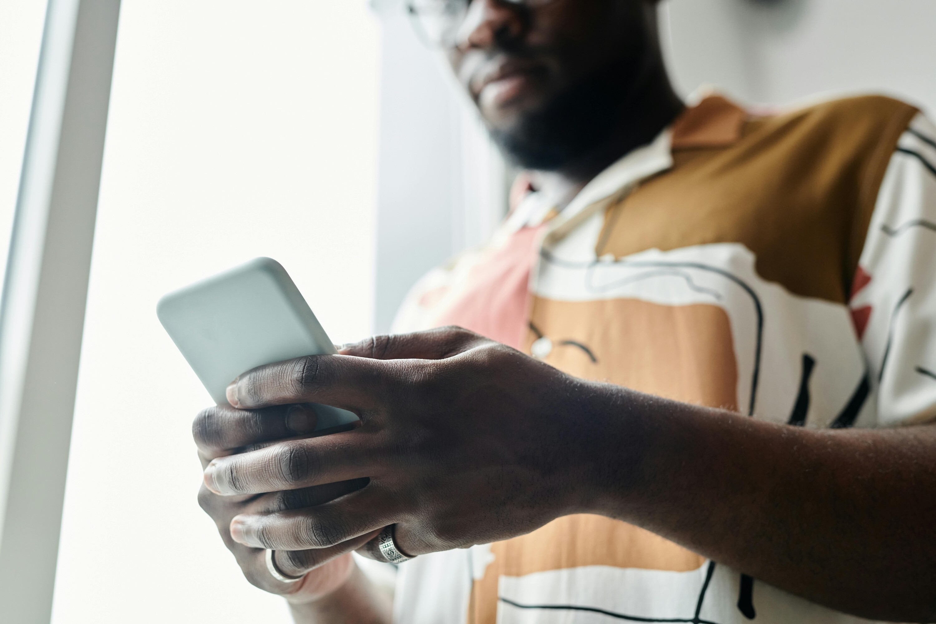 Person scrolling on their phone while reading online content and social media updates.
