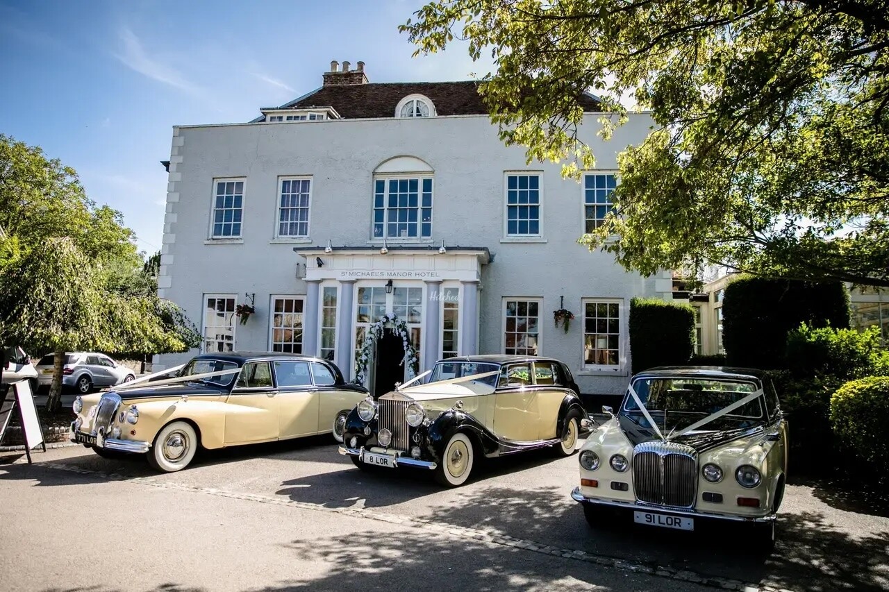 Exterior of St Michael’s Manor in St Albans with classic wedding cars parked outside the country house hotel