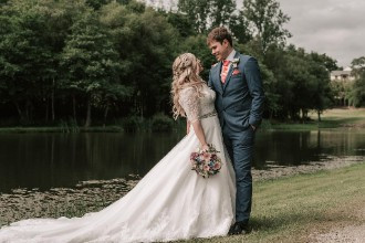 Bride and groom beside lake at St Mellion Estate