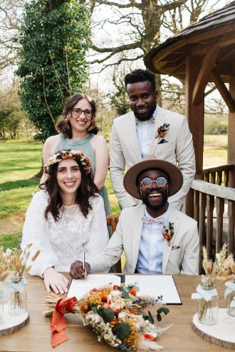 Wedding couple with witnesses signing documents 