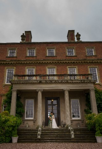 Ana and Satveer stood at the entrance of Davenport House, in an embrace.