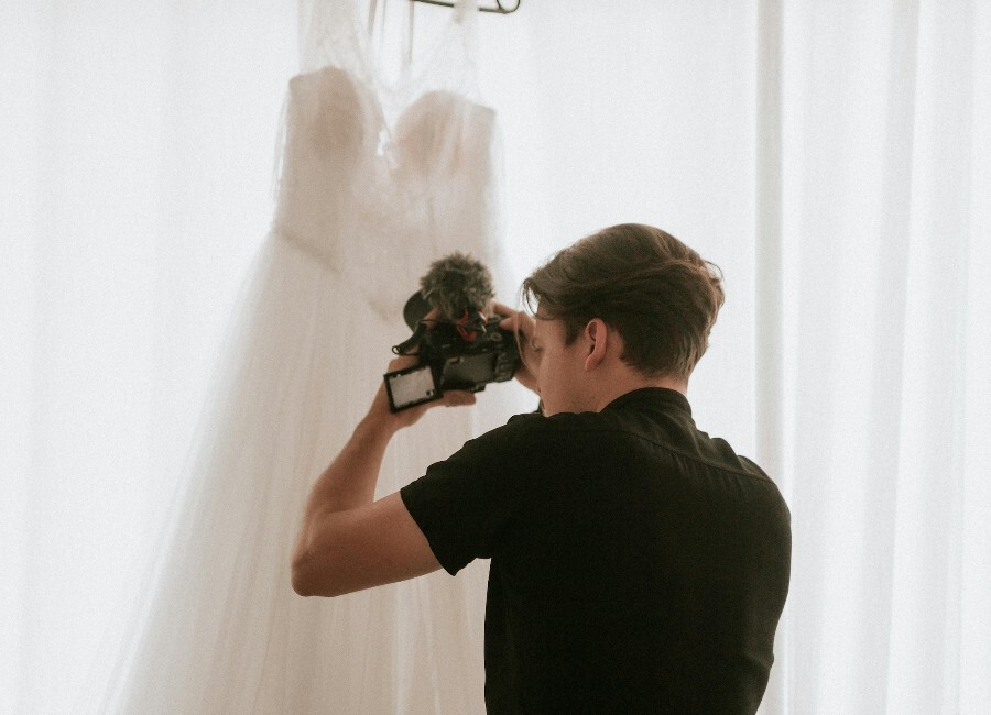 Wedding videographer capturing content of wedding dress