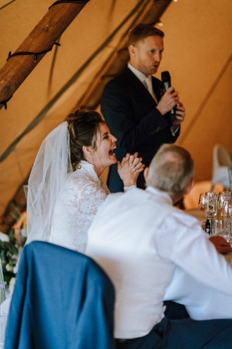 Bride laughing at the grooms speach