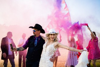 bride and groom with smoke bombs in pink and purple
