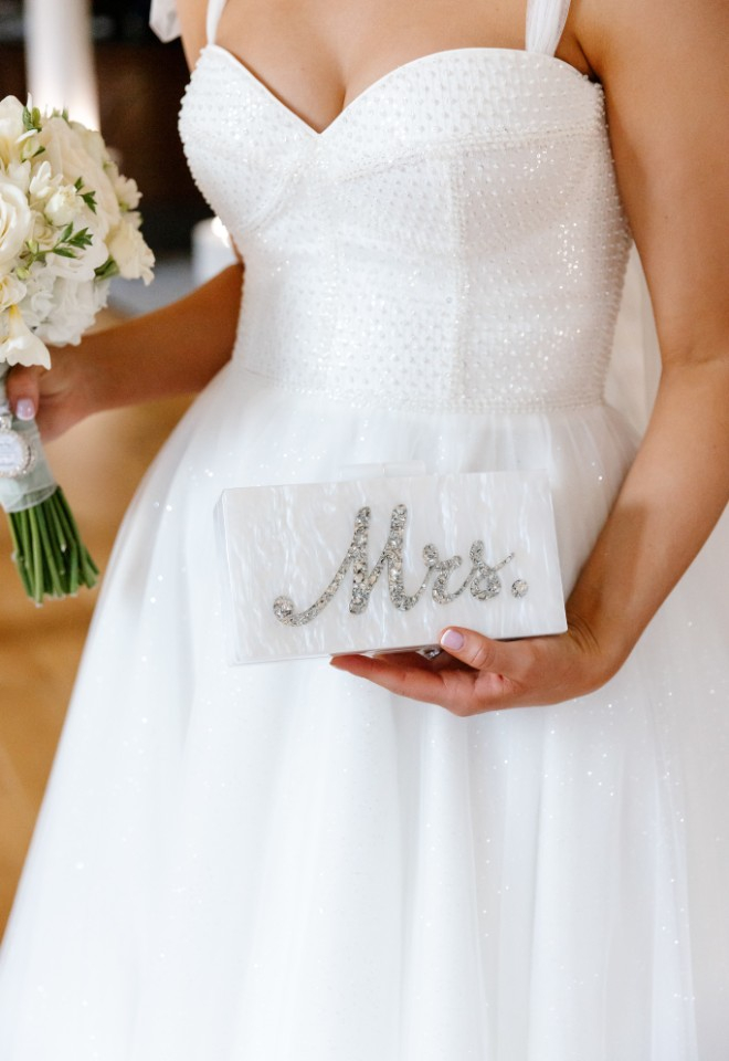 Bride holds Mrs clutch bag