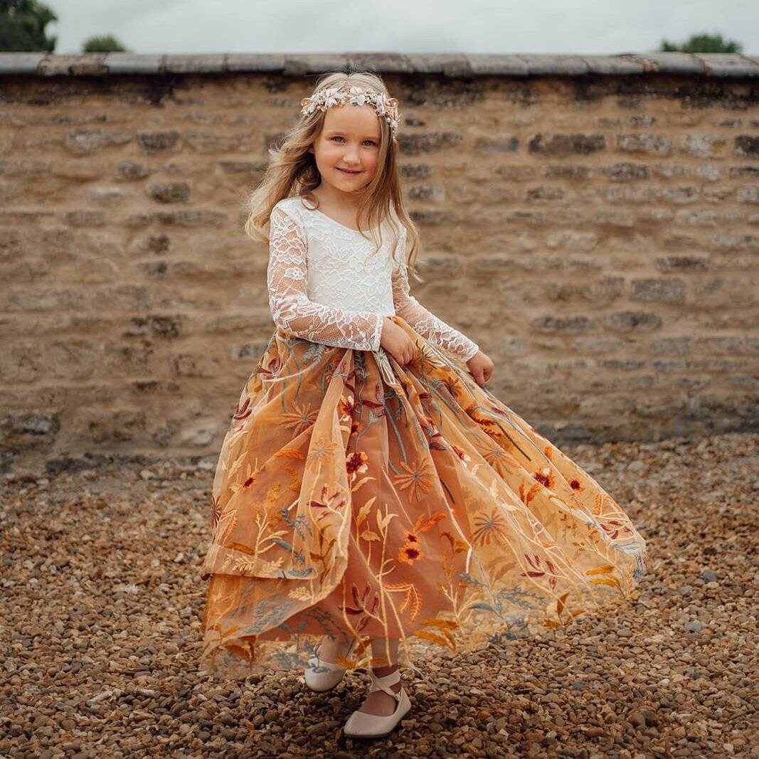 young girl in boho lace long sleeve dress with orange floral embroidery
