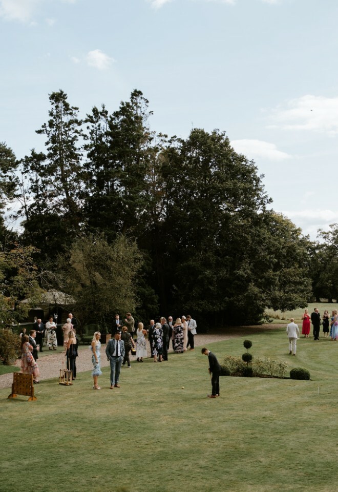Wedding guests playing lawn games by the pond at Davenport House
