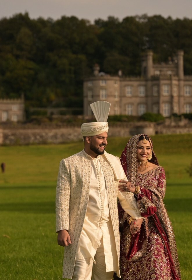 Bride holding grooms arm with the castle as a backdrop