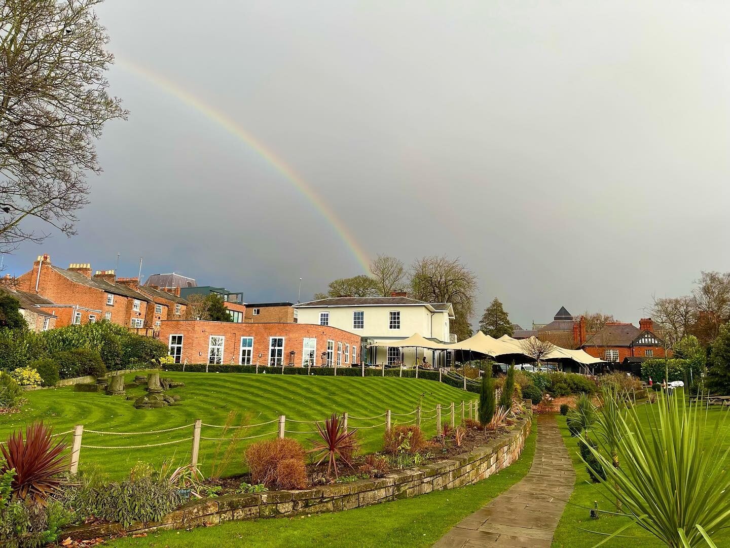 Exterior of The Architect pub and wedding venue in Cheshire, showing the gardens with a rainbow over the building