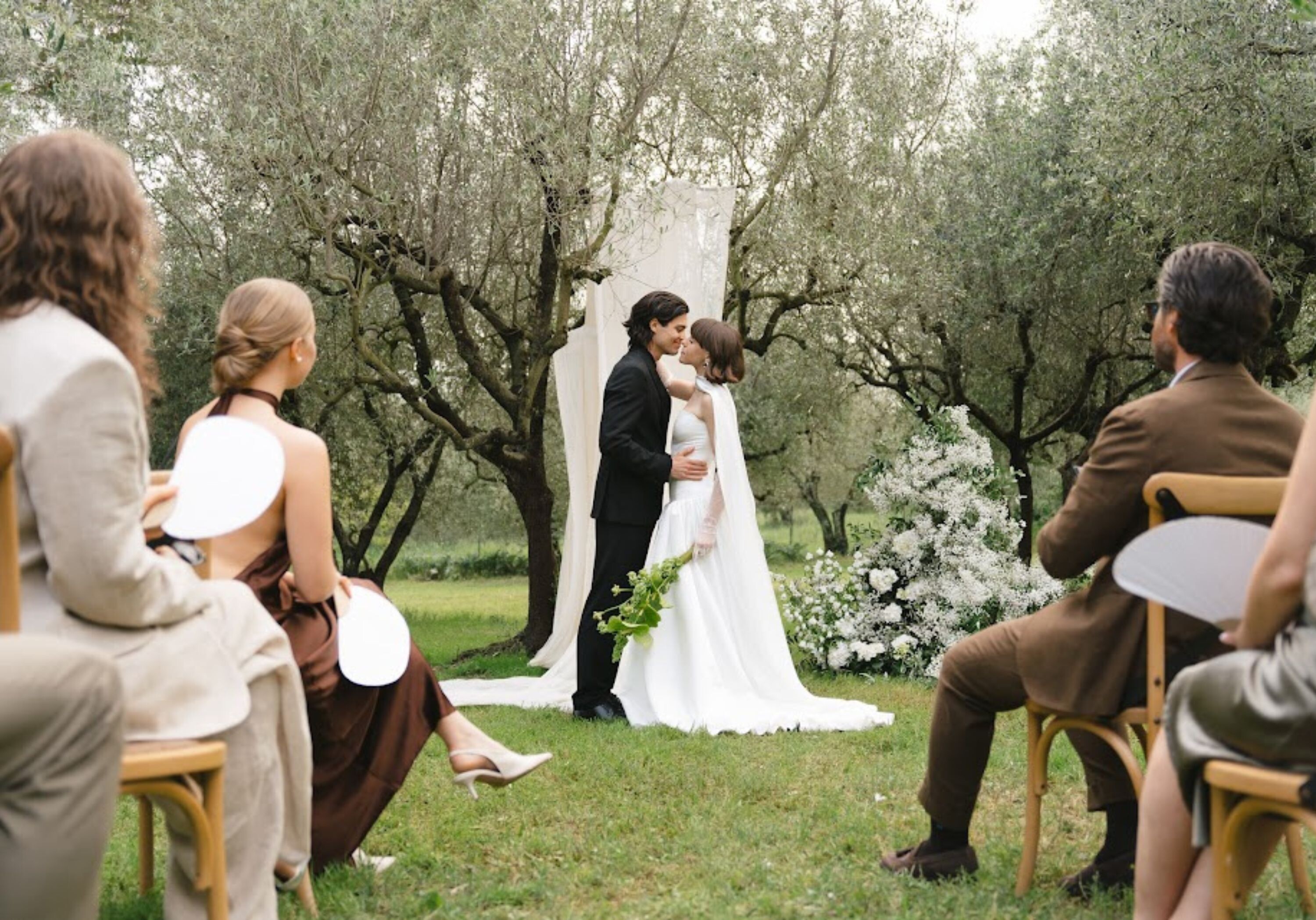 Couple exchanging vows during an intimate outdoor wedding ceremony surrounded by close family and friends