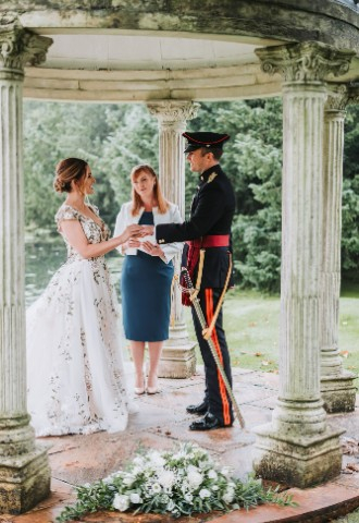 Bride and groom exchanging rings with celebrant Beth Whaley stood in between them