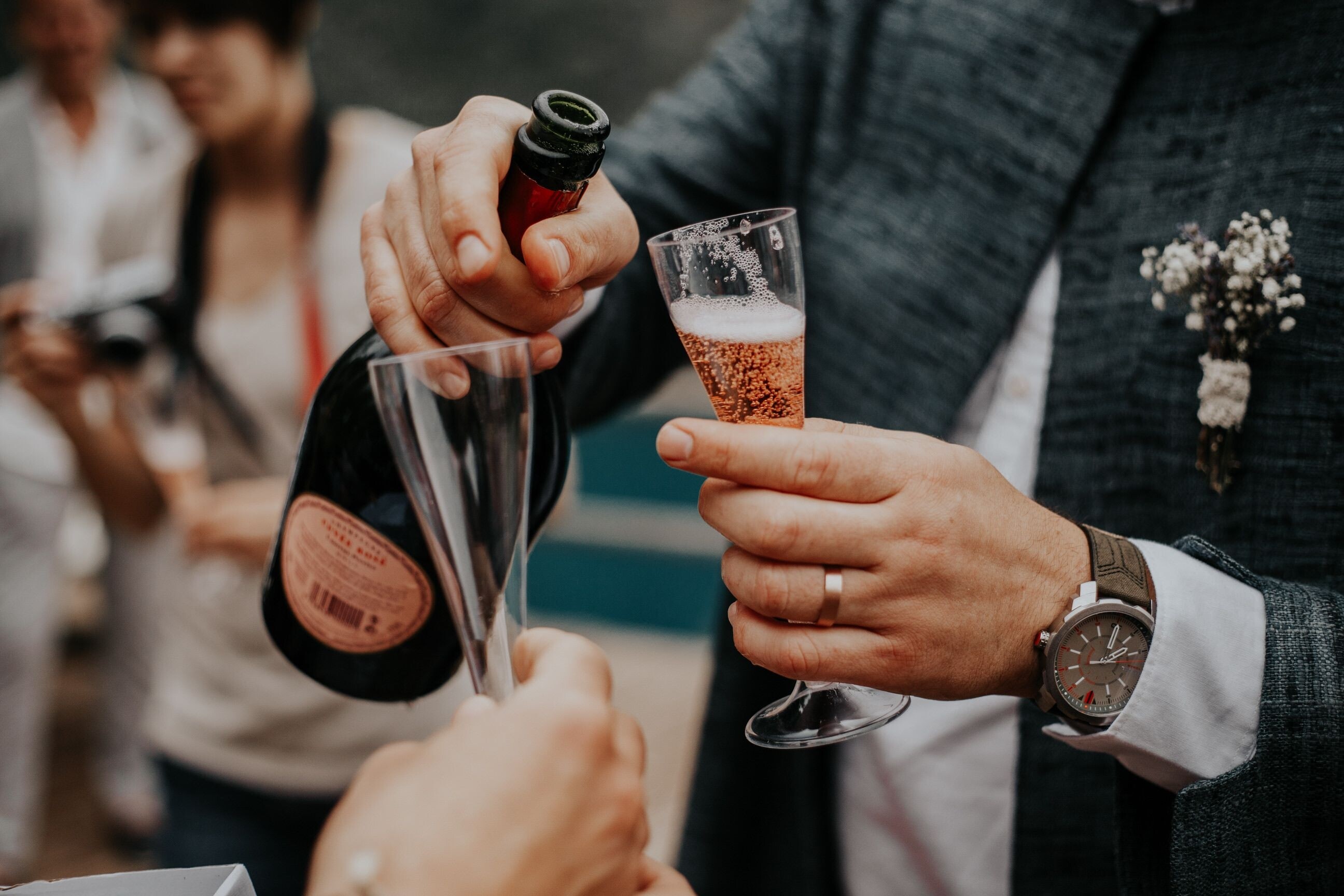 Rose sparkling wine being poured into glasses during a wedding