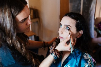 Bride getting makeup done on wedding morning